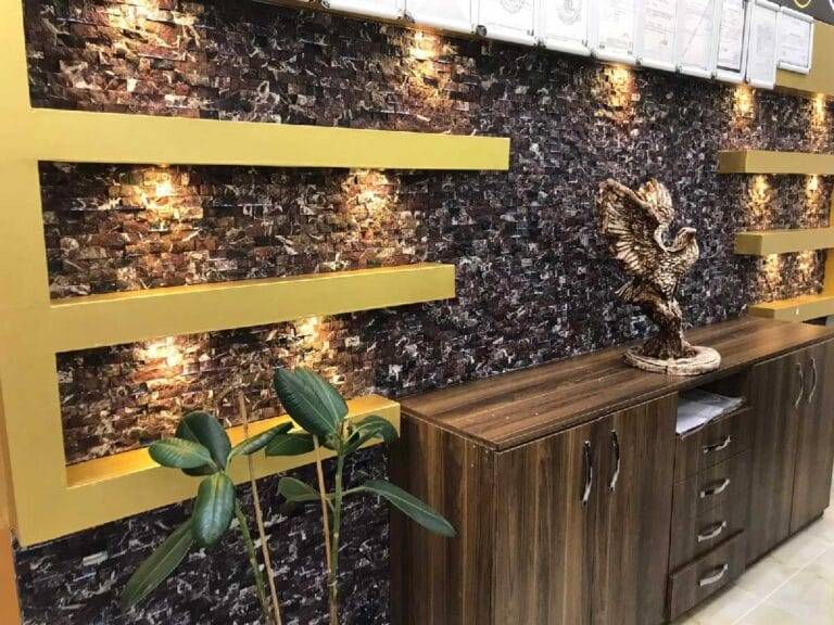 Dark natural split stone accent wall design for TV lounge interior in Pakistan